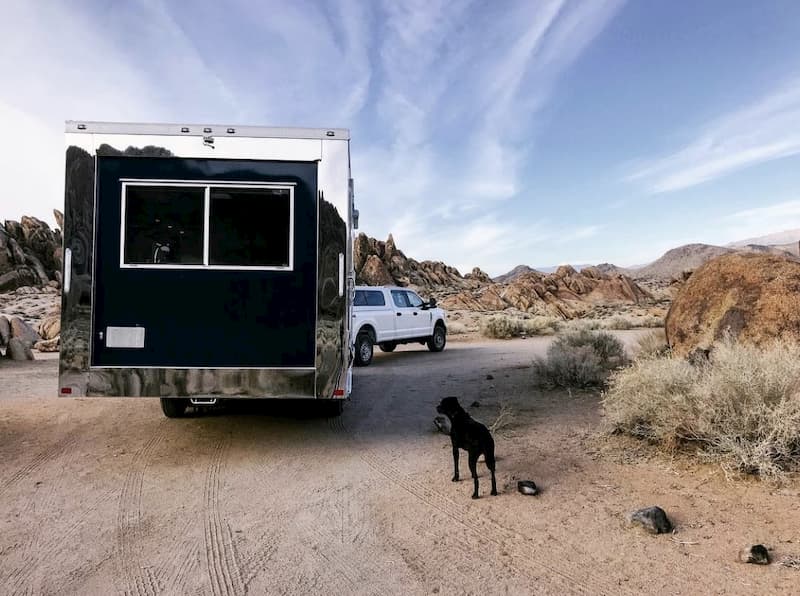 a dog in front of an off road travel trailer