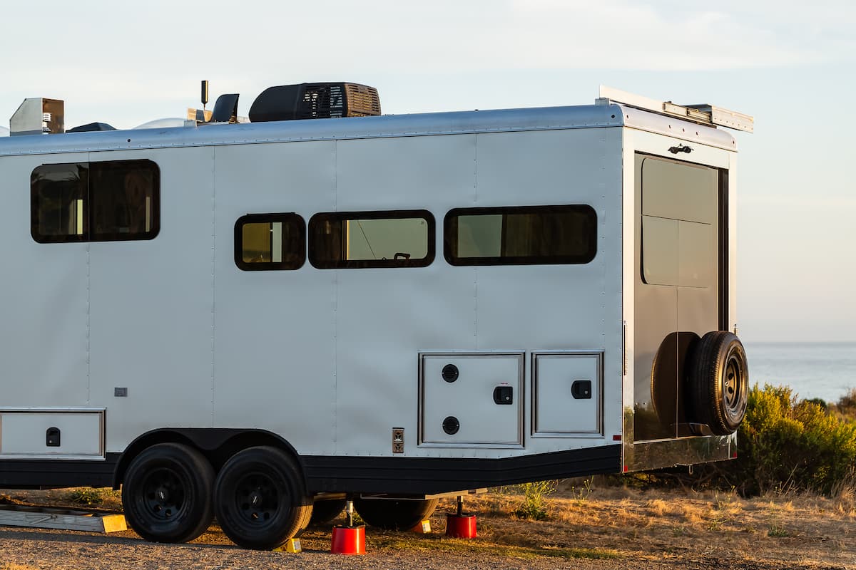 a luxury travel trailer in front of a bay