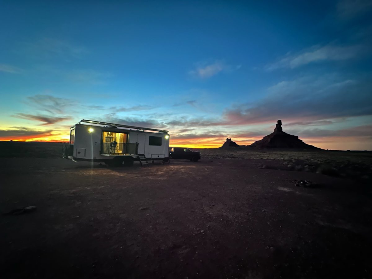 A Living Vehicle at sunset beside a desert butte